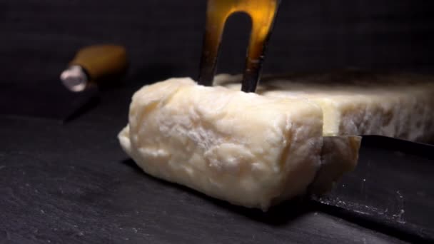Cortes de cuchillo y tenedor levanta trozo de queso de cabra — Vídeo de stock