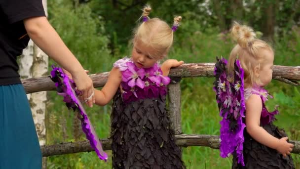 Mom helps the girl to put on butterfly wings — Stock Video