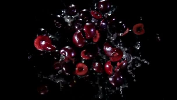 Целые половинки вишни с соком летят в камеру — стоковое видео