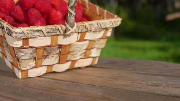 Framboises tombent du panier sur une table en bois — Video