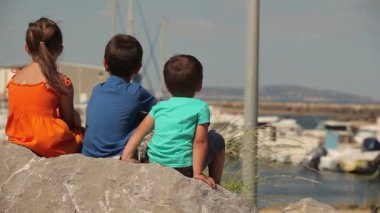 Çocuklar yatlarla koya bakıyorlar.