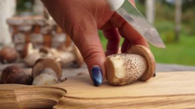 Bir bıçak ile ahşap bir tahta üzerinde mantar kesilmiş