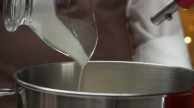 Cook kırbaçlama için metal bir kase içine krem döker