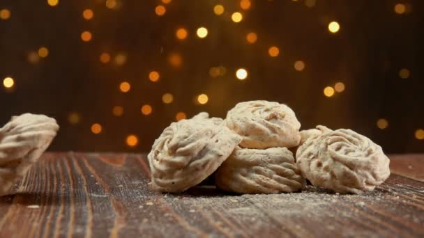 Galletas de merengue caen sobre una superficie de madera — Vídeo de stock