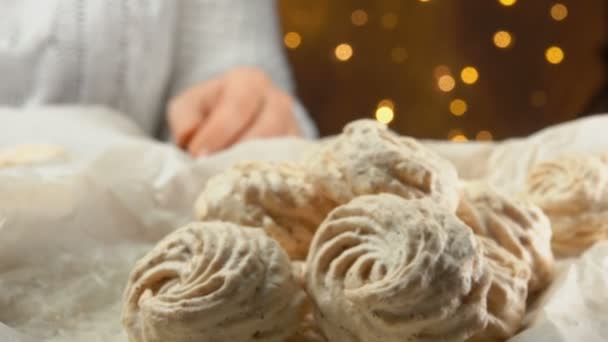Hand neemt meringue cookies van een bakplaat — Stockvideo