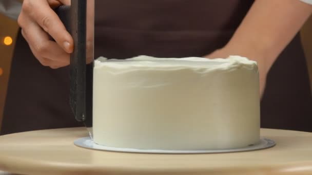 Шеф-повар сглаживает крем на торте лопаткой — стоковое видео