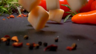 Sert peynir küpleri siyah bir yüzeye düşer 