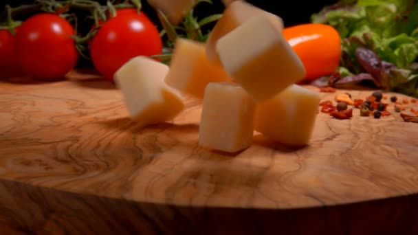 Los cubos de queso duro caen en la tabla con las especias — Vídeos de Stock