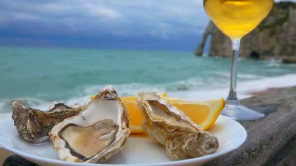 Bord vol verse oesters en glas witte wijn — Stockvideo