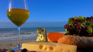 Deniz kenarında romantik bir piknik Beyaz şarap, peynir