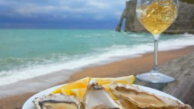 Okyanus kıyısında beyaz şarap ve istiridye.