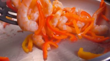 Karides ve biber iki spatulayla karıştırılır.