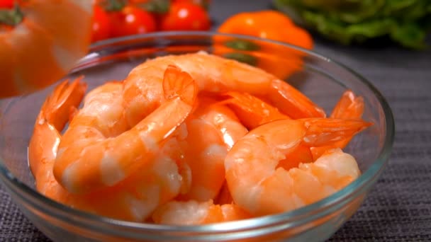 Hand puts one peeled shrimp in a glass bowl — Stock Video
