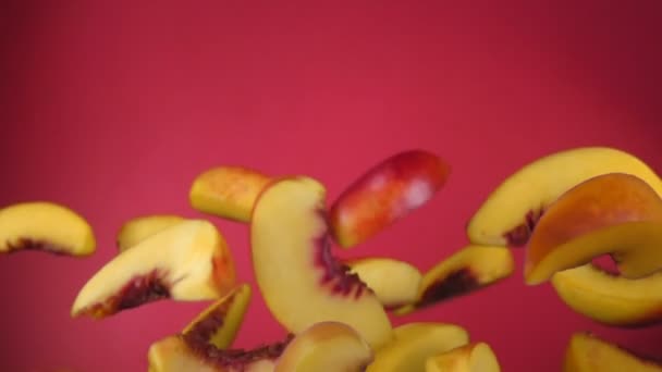 Pfirsichscheiben prallen auf rotem Hintergrund ab — Stockvideo