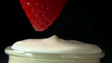 Krem şantiye içine batırılmış çilek yakın plan.