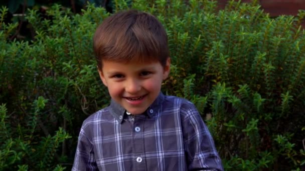 Leende pojke leker utomhus — Stockvideo