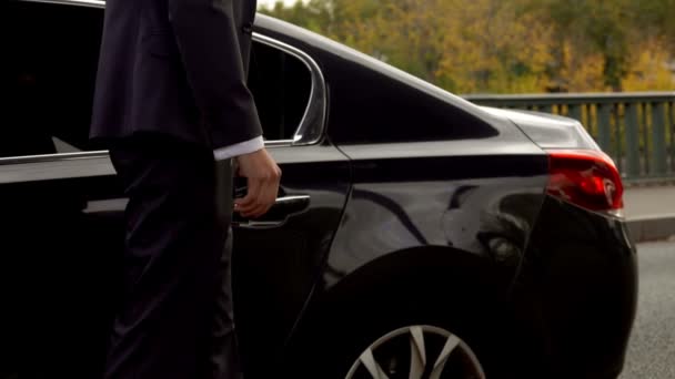 Персональний водій відкриває двері автомобіля для свого клієнта — стокове відео