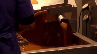 İşçi çikolata karıştırıcısının yanında duruyor.