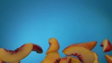 Şeftali dilimleri mavi arkaplanda zıplar