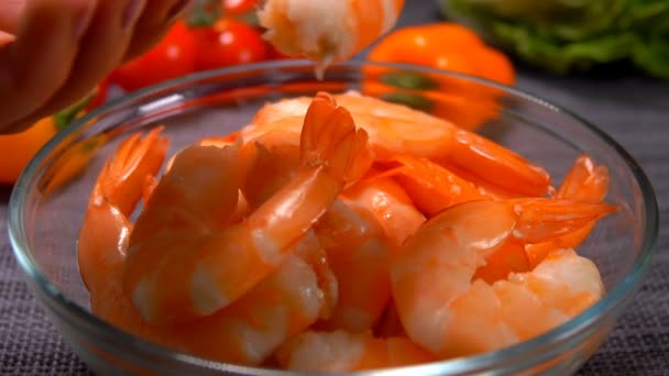Hand puts delicious large shrimp in a glass bowl — Stock Video