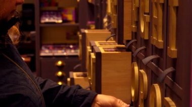 Kadın şekerci dükkanında çikolataya bakıyor.