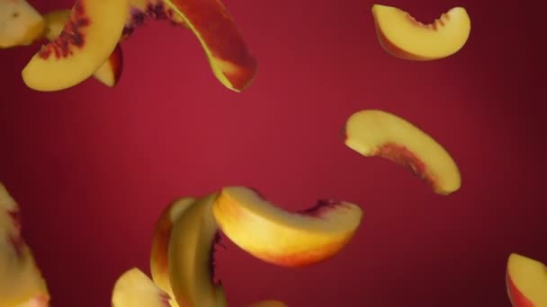 Pfirsichscheiben fliegen auf rotem Hintergrund herunter — Stockvideo