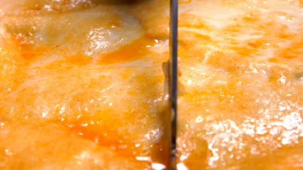 Italian lasagna cut with knife in backing pan — Stock Video