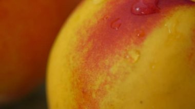 Olgun bir şeftalinin üzerinden akan bir damla su.