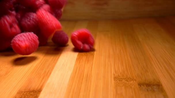 Большая сочная малина вытекает из плетеной корзины — стоковое видео