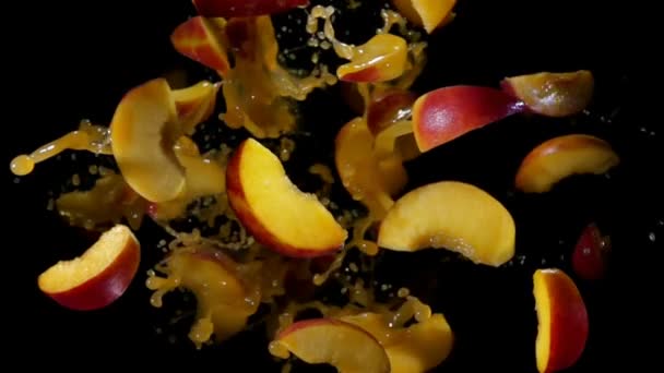 Slices of peach fly up in splashes of juice — Stock Video