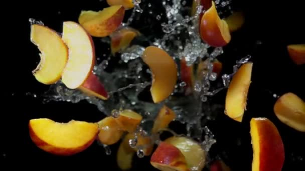 Skivor persikor studsar i stänk av vatten — Stockvideo