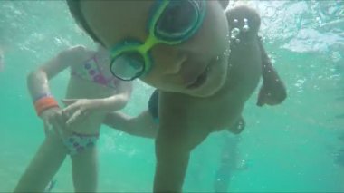 Yüzme gözlüklü çocuk suyun altında dalıp yüzüyor.