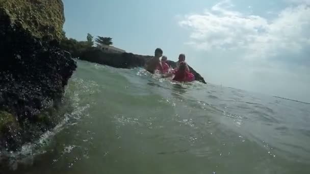 Deniz dalgalarında zıplayan bir grup çocuk. — Stok video