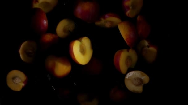 Pfirsichhälften fliegen in Wasserspritzern — Stockvideo