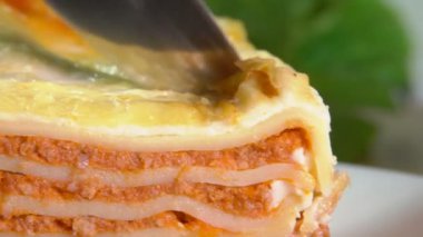 Bıçak bir parça leziz İtalyan lazanyası kesiyor.