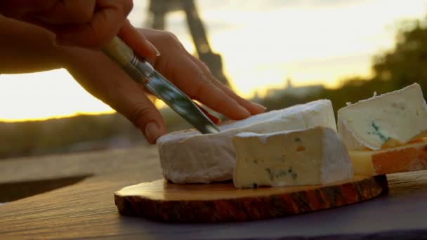 Hand Scheiben Brie-Käse in Abschnitte auf einem Brett — Stockvideo