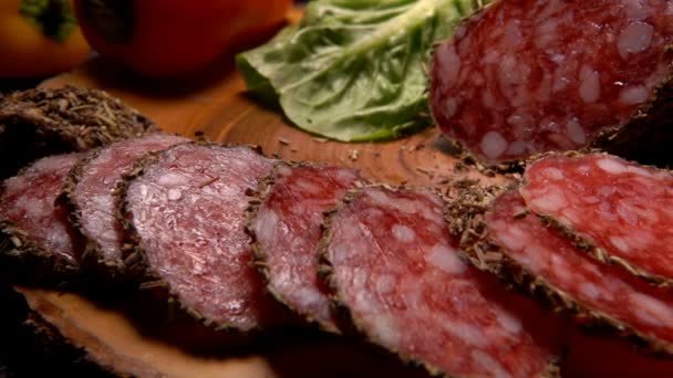 Fork takes slices of dried sausage in herbs — Stock Video