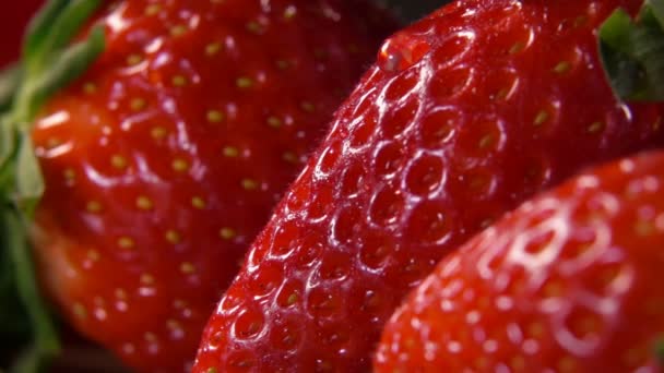 Rote Erdbeeren mit Wasser, das über die Oberfläche fließt — Stockvideo