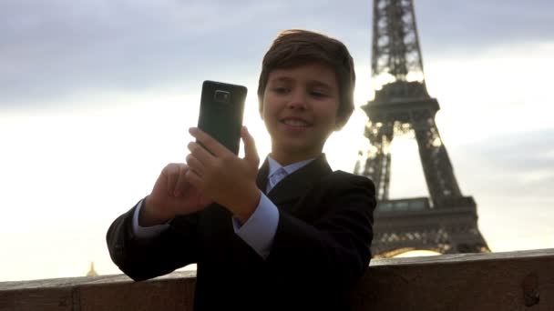 Boy hace selfie en el telón de fondo de la Torre Eiffel — Vídeo de stock