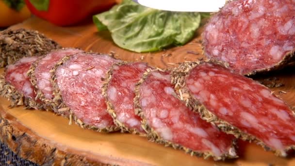 Sharp knife cut a slice of dried sausage in herbs — Stock Video