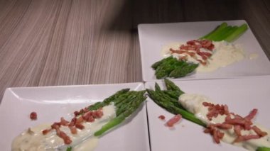 Peynir soslu jambonlu kuşkonmaz tabakları.
