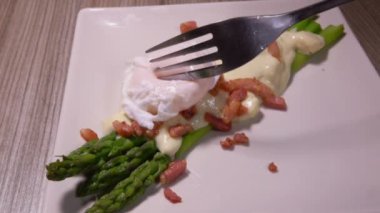 Haşlanmış yumurta soslu kuşkonmaz üzerine konur.