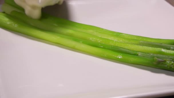 La salsa de queso se coloca en espárragos hervidos verdes — Vídeos de Stock