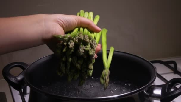 Asparagus stems are thrown into boiling water — Stock Video