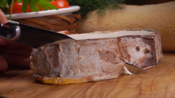 Сливочный французский сыр Epoisses вырезанный на деревянной доске — стоковое видео