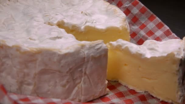 Sector of soft camambert cheese lies next to whole — Stock video