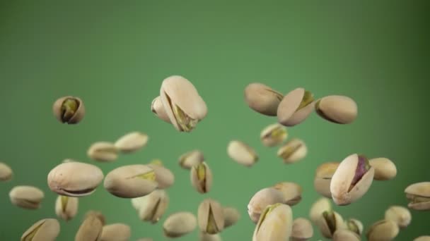 Primer plano de los pistachos volando hacia arriba y girando sobre el fondo verde oliva — Vídeo de stock