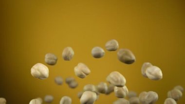 Fındıkları kapatın ve sarı arka planda döndürün