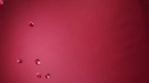 Les grains de grenade volent en diagonale sur un fond rouge au ralenti 