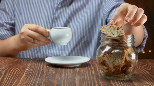 Mujer toma galletas de cantucci de un frasco de vidrio y lo sumerge en el café expreso — Vídeos de Stock